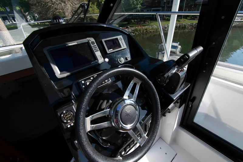 Slide: The Image of Cockpit of 2017 Jeanneau NC 895 boat with steering wheel and navigation controls. - 16
