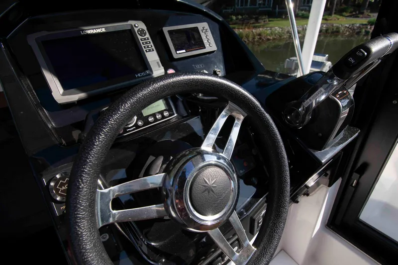 Slide: The Image of Steering wheel and controls of a 2017 Jeanneau NC 895 boat cockpit. - 17
