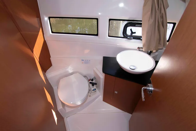 Slide: The Image of 2017 Jeanneau NC 895 boat bathroom with toilet, sink, and window. - 21