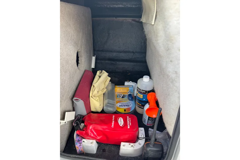 Slide: The Image of Storage compartment of 2022 Stingray 192 SC boat with safety and maintenance items. - 15