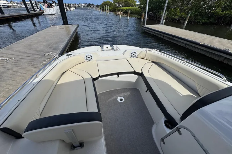 Slide: The Image of 2022 Stingray 192 SC boat interior with beige seating, docked by the water. - 17