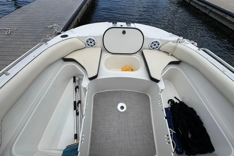 Slide: The Image of 2022 Stingray 192 SC boat interior with seating, storage compartments, and dockside view. - 18