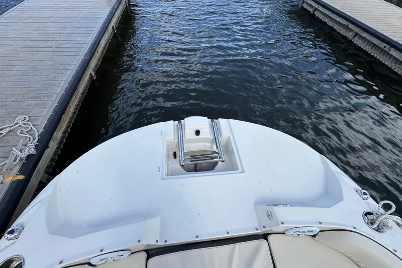 Slide: The Image of 2022 Stingray 192 SC boat docked between piers on calm water. - 20