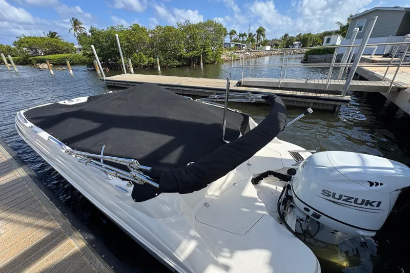 Slide: The Image of 2022 Stingray 192 SC boat with Suzuki outboard motor docked by the water. - 23