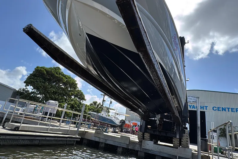 Slide: The Image of 2022 Stingray 192 SC boat being lifted at a yacht center under a clear sky. - 25
