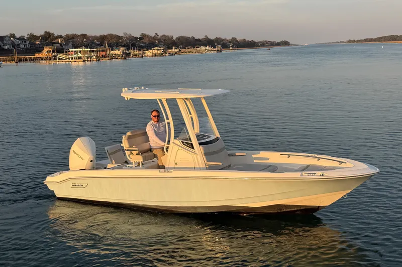 Slide: The Image of 2023 Boston Whaler 220 Dauntless boat on calm water, with a person onboard. - 3