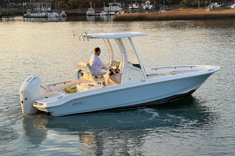 Slide: The Image of 2023 Boston Whaler 220 Dauntless boat cruising on calm waters at sunset. - 33