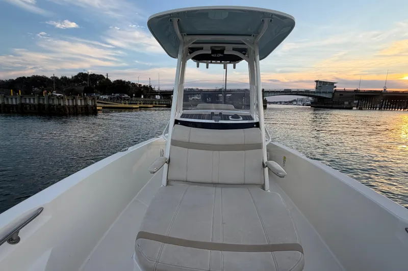 Slide: The Image of 2023 Boston Whaler 220 Dauntless boat on water at sunset near a bridge. - 37