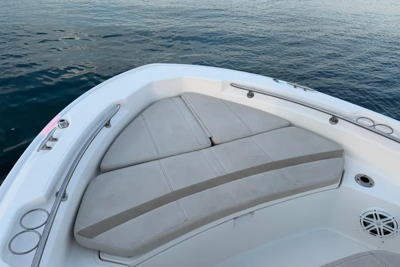 Slide: The Image of 2023 Boston Whaler 220 Dauntless boat interior with cushioned seating, on calm water. - 39