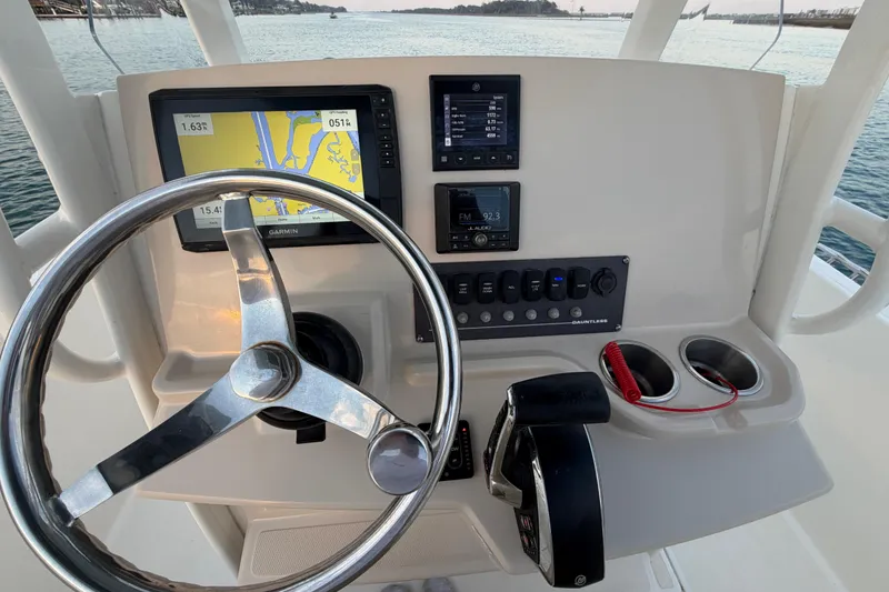 Slide: The Image of Boston Whaler 220 Dauntless 2023 helm with navigation screens and steering wheel. - 45
