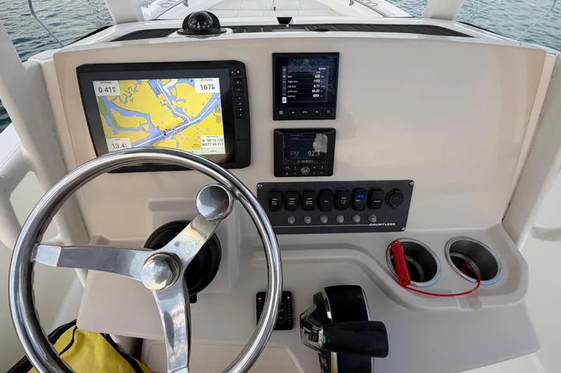 Slide: The Image of 2023 Boston Whaler 220 Dauntless helm with navigation screens and controls. - 49