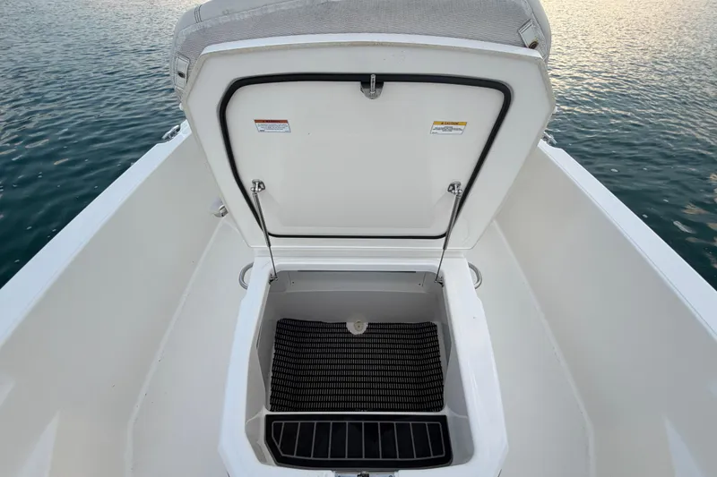Slide: The Image of Open storage compartment on 2023 Boston Whaler 220 Dauntless boat, near water. - 56