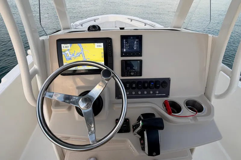 Slide: The Image of 2023 Boston Whaler 220 Dauntless helm with navigation display and controls. - 61
