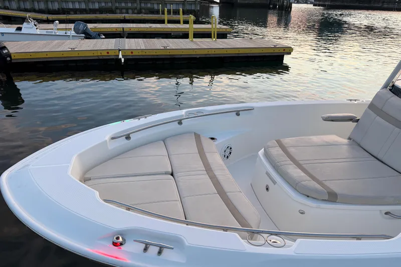 Slide: The Image of 2023 Boston Whaler 220 Dauntless boat interior with cushioned seating at dock. - 66