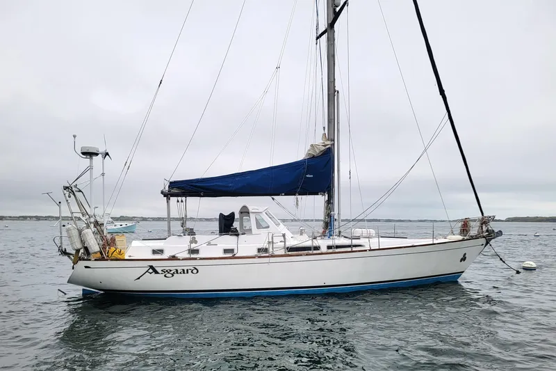 Slide: The Image of 1981 CT 49 sailboat named Asgaard on calm waters with blue sail cover. - 7