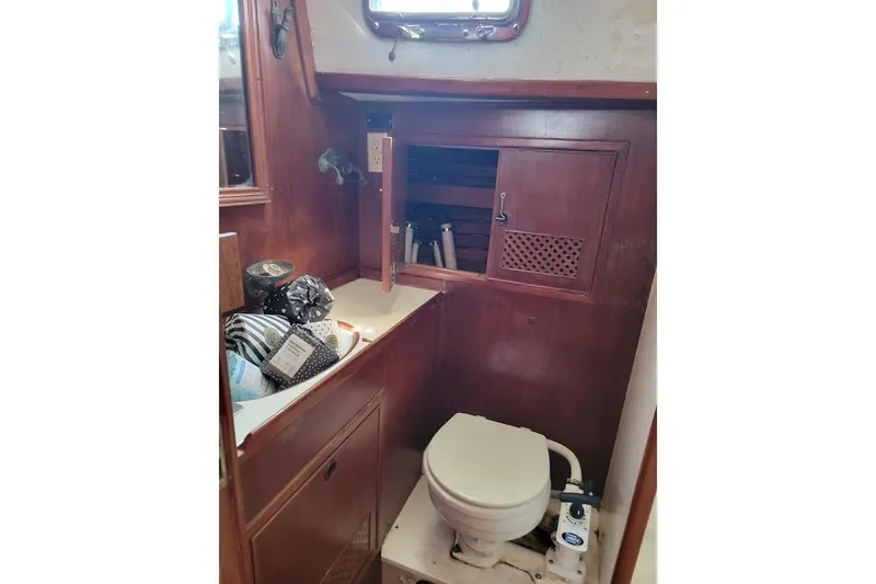 Slide: The Image of 1981 CT 47 yacht bathroom with wooden cabinetry and marine toilet. - 23