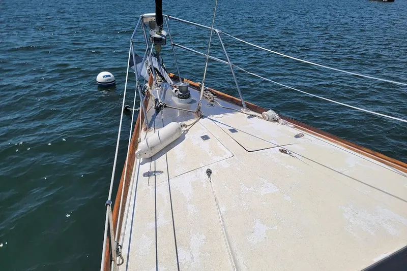 Slide: The Image of Sailboat deck on water, CT 47 model, 1981, with visible rigging and buoy nearby. - 8
