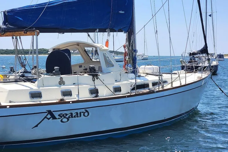 Slide: The Image of 1981 CT 47 sailboat "Asgaard" anchored in calm waters with blue sails. - 5