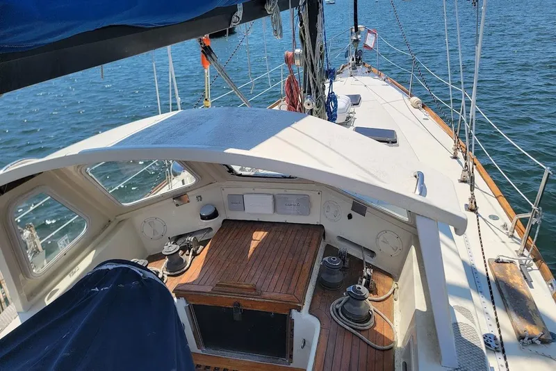Slide: The Image of 1981 CT 47 sailboat deck with wooden accents and nautical equipment on open water. - 26