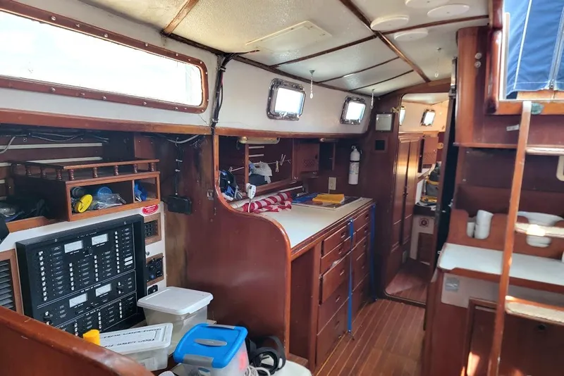 Slide: The Image of Interior of a 1981 CT 47 sailboat with wooden cabinetry and navigation equipment. - 16
