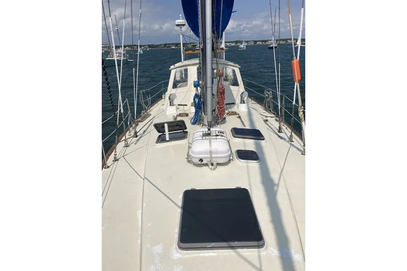 Slide: The Image of 1982 CT 47 sailboat deck with blue sail, moored in a marina. - 36