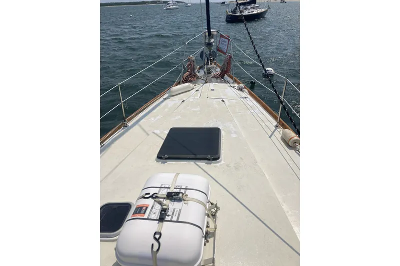 Slide: The Image of 1982 CT 47 sailboat deck with life raft, moored in calm waters. - 35
