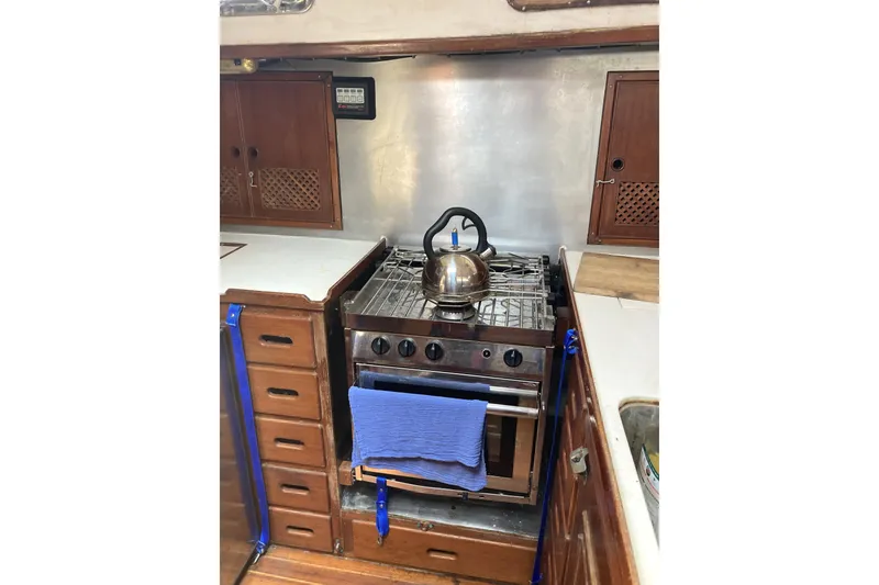 Slide: The Image of Vintage 1982 CT 47 yacht kitchen with stove, kettle, and wooden cabinetry. - 18