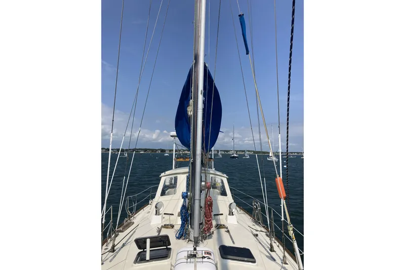 Slide: The Image of Sailing on a 1982 CT 47 yacht, calm waters, clear sky, anchored boats in the distance. - 37