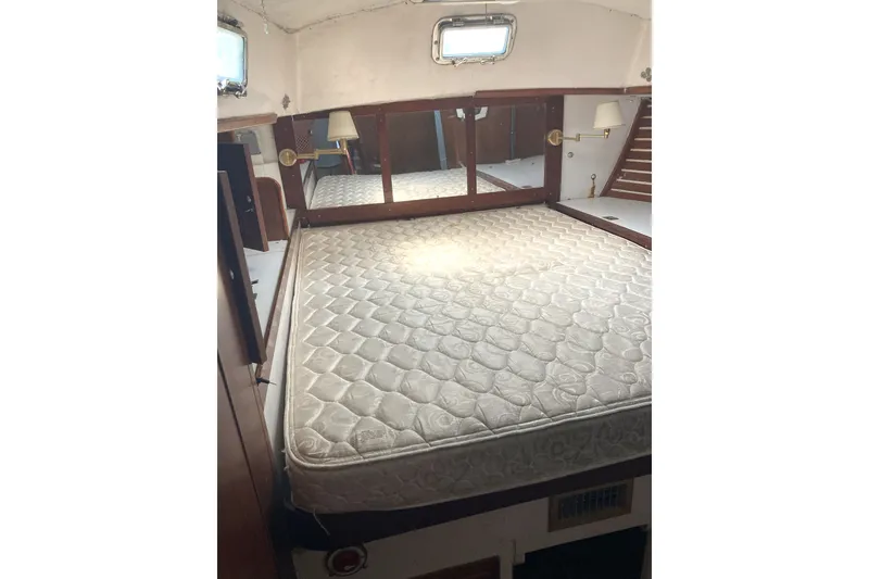 Slide: The Image of Interior of 1982 CT 47 yacht with a spacious bed and wooden accents. - 20