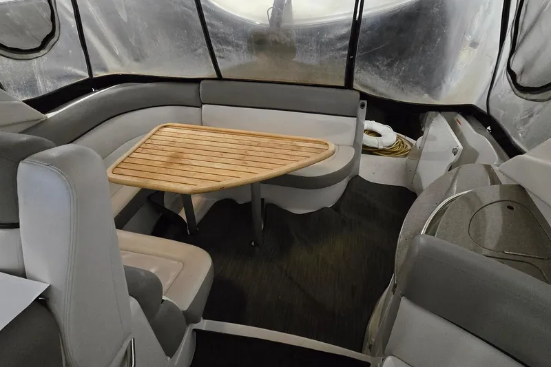 Slide: The Image of Interior of 2018 Four Winns V355 boat with seating and wooden table. - 2