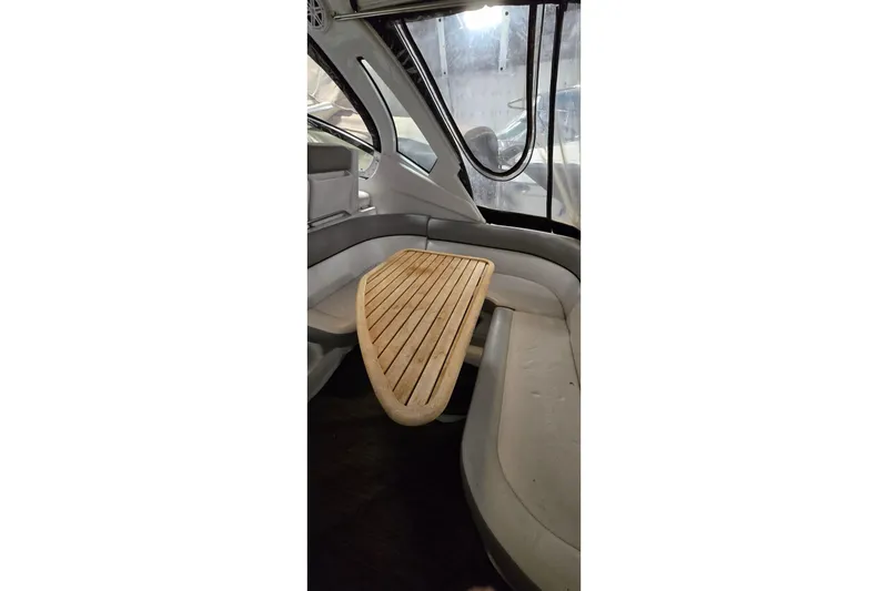 Slide: The Image of Interior of 2018 Four Winns V355 boat with wooden table and cushioned seating. - 3
