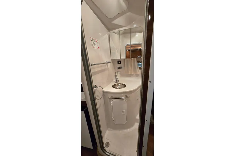 Slide: The Image of Compact bathroom in 2018 Four Winns V355 boat, featuring a sleek sink and mirror. - 35