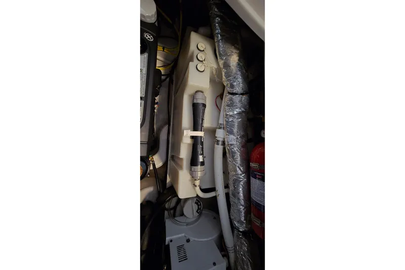 Slide: The Image of Engine compartment of 2018 Four Winns V355 boat, featuring mechanical components and fire extinguisher. - 36