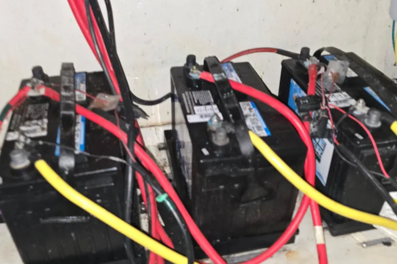 Slide: The Image of Three marine batteries with red and yellow cables in a 2018 Four Winns V355 boat. - 45
