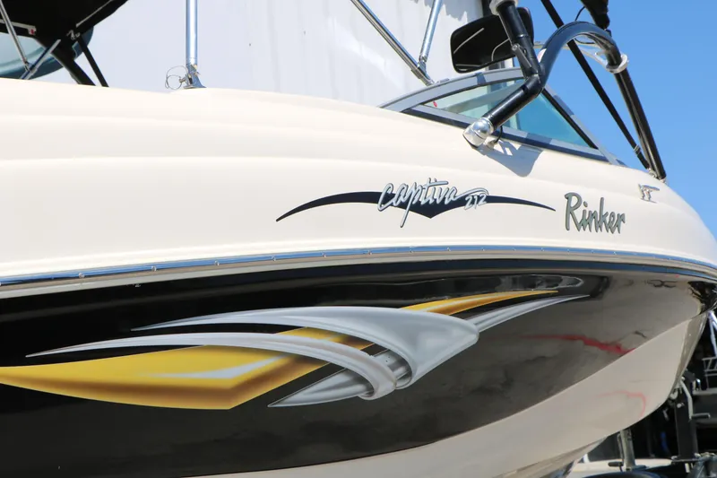 Slide: The Image of 2004 Rinker 212 Captiva Bowrider boat with sleek design and stylish graphics. - 11