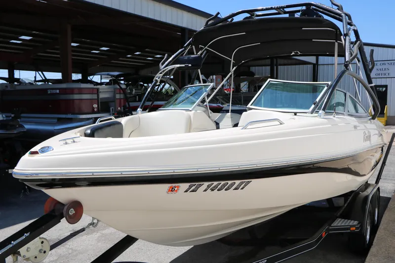 Slide: The Image of 2004 Rinker 212 Captiva Bowrider boat on trailer, parked in marina. - 14