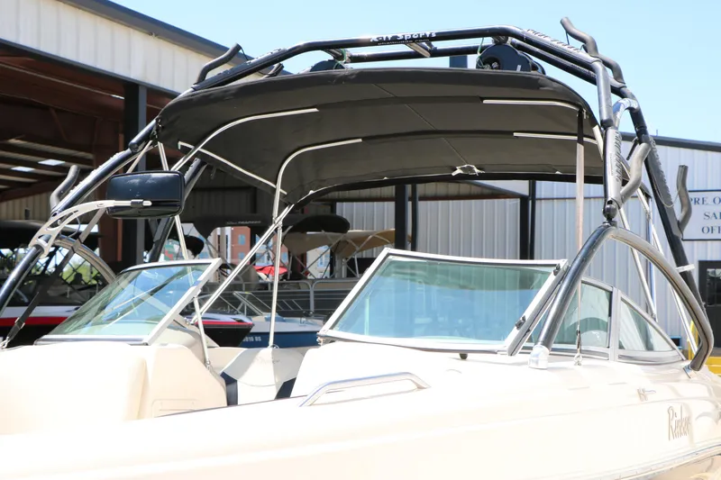 Slide: The Image of 2004 Rinker 212 Captiva Bowrider with wakeboard tower in a marina setting. - 15