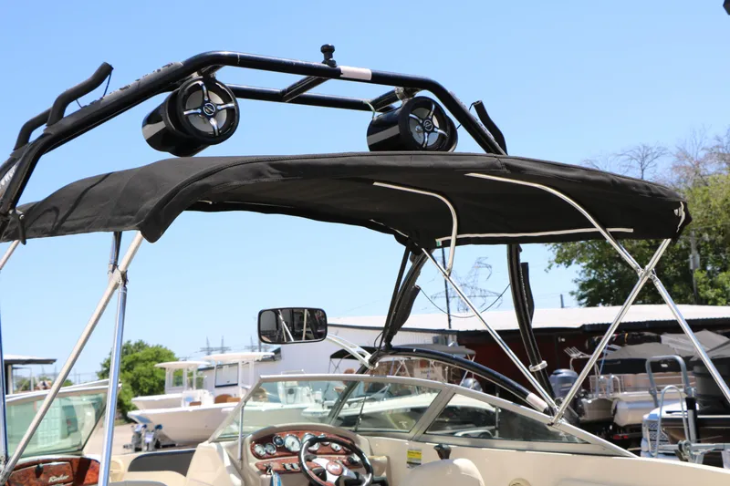 Slide: The Image of 2004 Rinker 212 Captiva Bowrider with black bimini top and wakeboard tower speakers. - 17