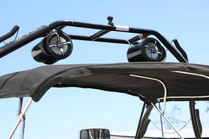 Slide: The Image of 2004 Rinker 212 Captiva Bowrider with speakers on wakeboard tower, blue sky background. - 18