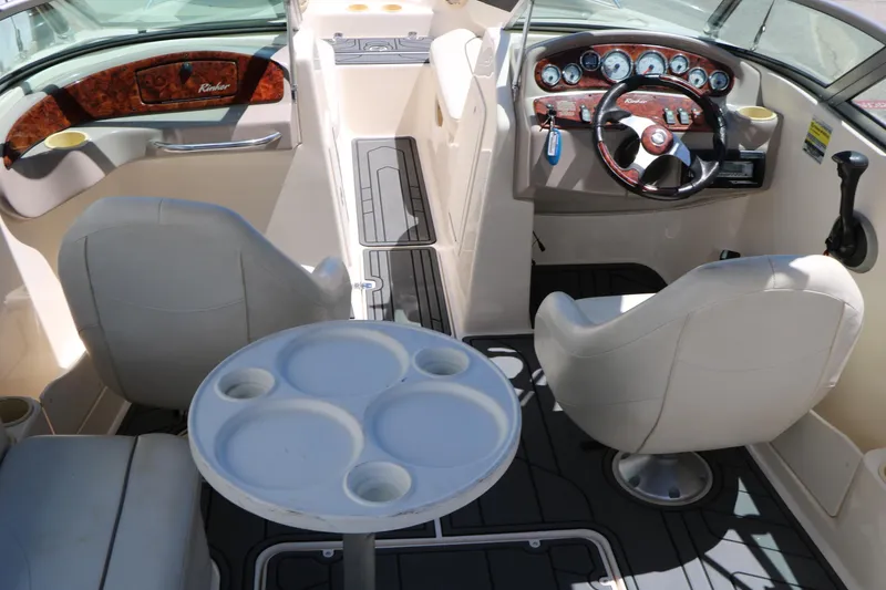 Slide: The Image of 2004 Rinker 212 Captiva Bowrider interior with steering wheel, seating, and cup holders. - 24