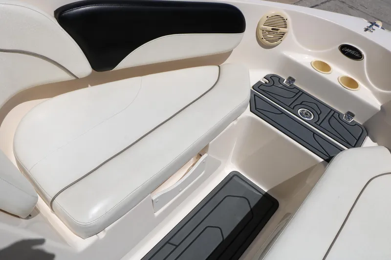 Slide: The Image of Interior of 2004 Rinker 212 Captiva Bowrider, featuring white seating and cup holders. - 36