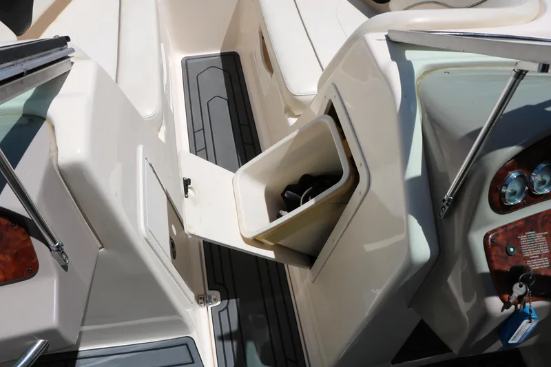 Slide: The Image of 2004 Rinker 212 Captiva Bowrider interior with open storage compartment and dashboard view. - 37