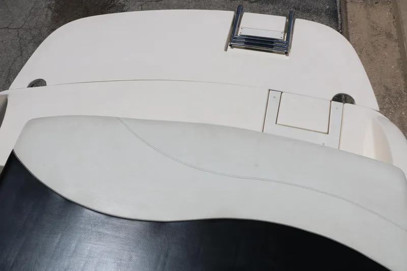 Slide: The Image of 2004 Rinker 212 Captiva Bowrider boat interior with white seating and swim platform. - 44