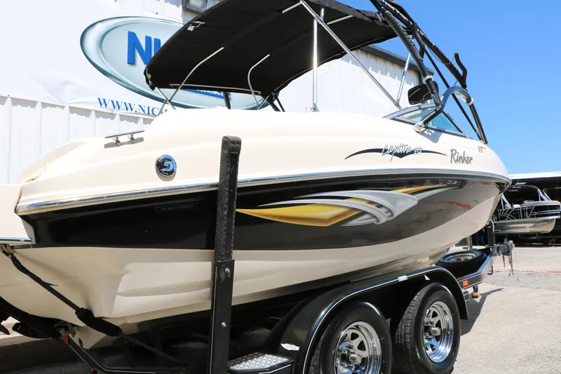 Slide: The Image of 2004 Rinker 212 Captiva Bowrider boat on trailer, featuring sleek design and black accents. - 9