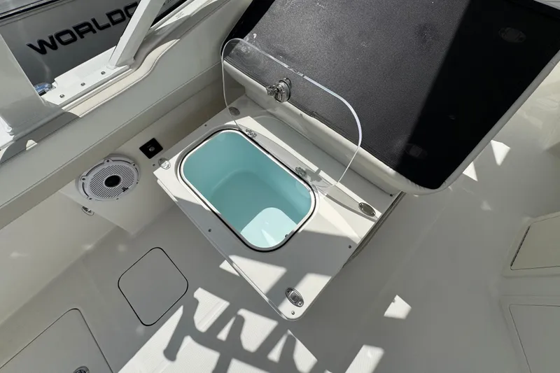 Slide: The Image of Open storage compartment on 2026 World Cat 280 DC-X boat deck, featuring a built-in speaker. - 10