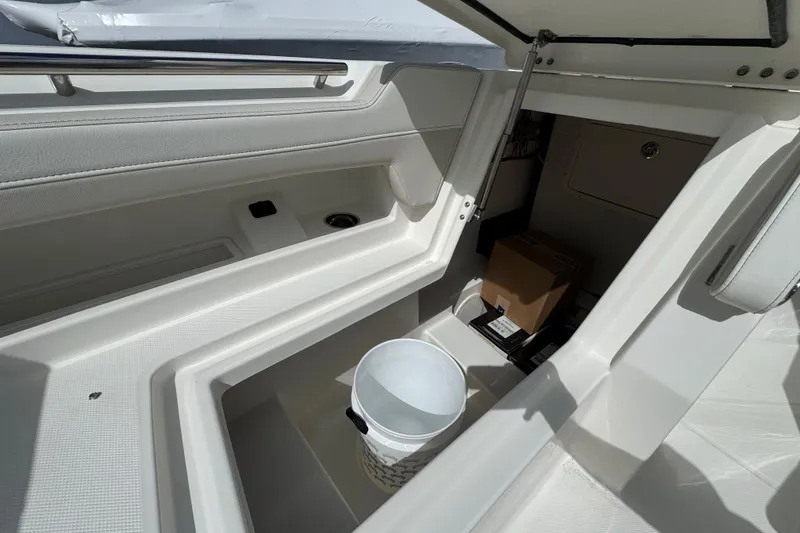 Slide: The Image of Interior storage compartment of 2026 World Cat 280 DC-X boat with bucket and boxes. - 7