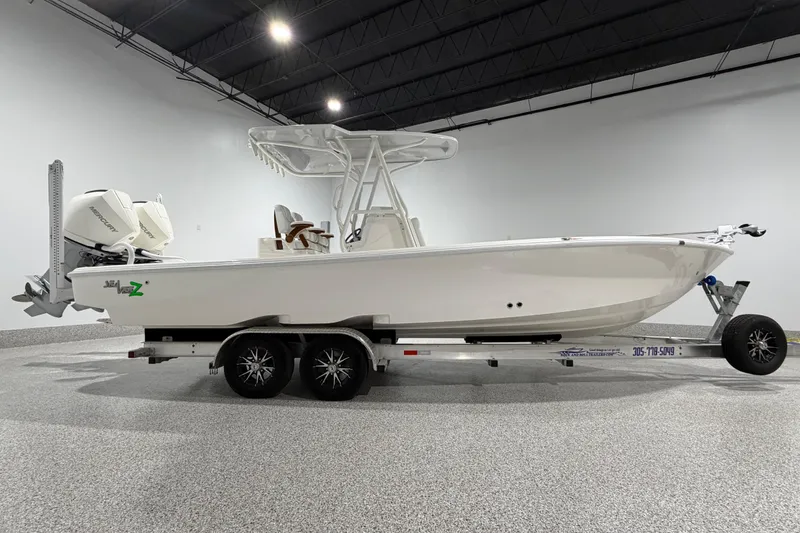 The Image of 2025 SeaVee 270Z boat on trailer in a showroom, featuring a sleek design and powerful engine. - 0