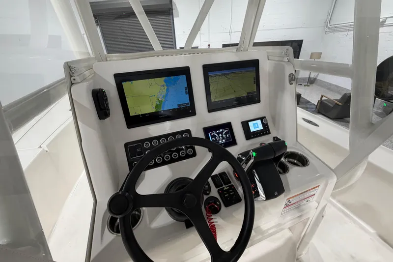 Slide: The Image of 2025 SeaVee 270Z boat dashboard with navigation screens and steering wheel. - 26
