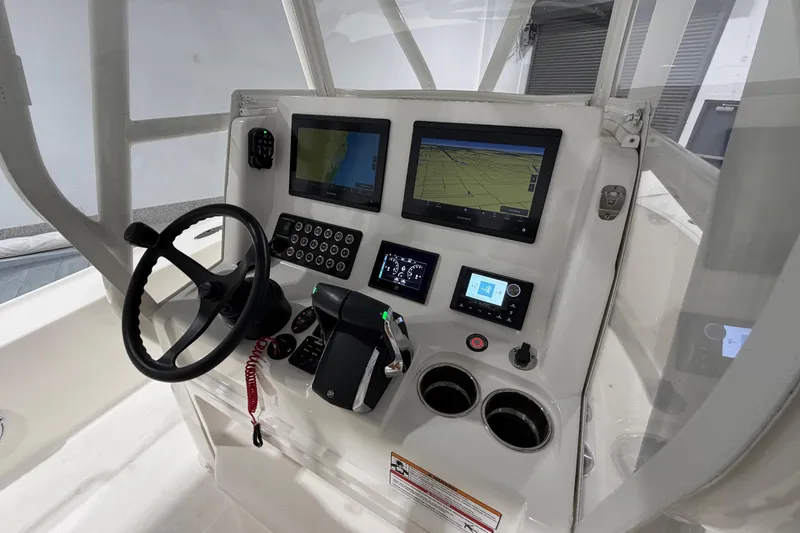 Slide: The Image of 2025 SeaVee 270Z boat dashboard with steering wheel, navigation screens, and controls. - 27