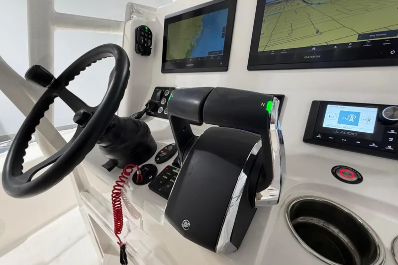 Slide: The Image of 2025 SeaVee 270Z boat dashboard with steering wheel, Garmin displays, and JL Audio system. - 30